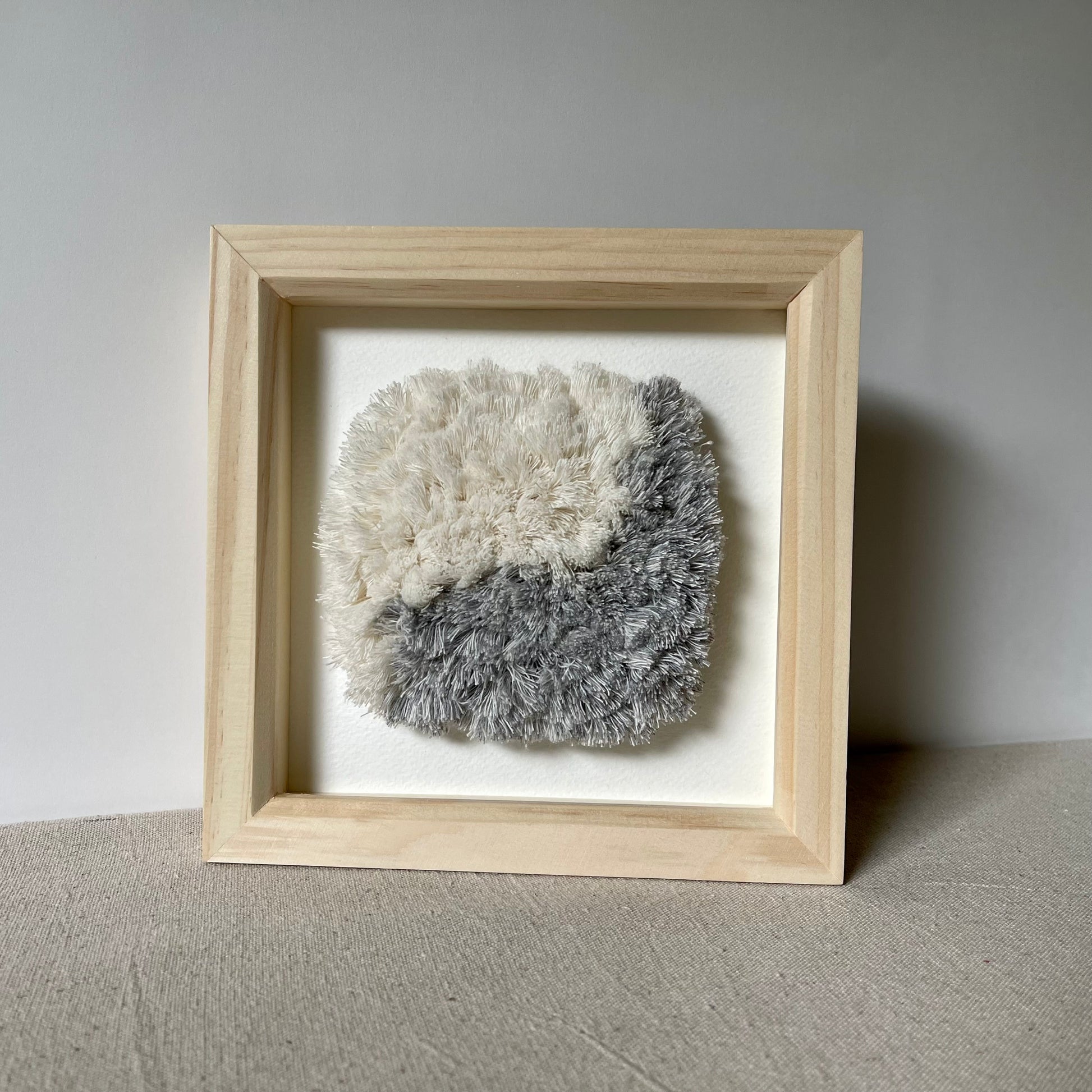 Blue and cream fluffy textured woven textile art in square natural wood deep box frame