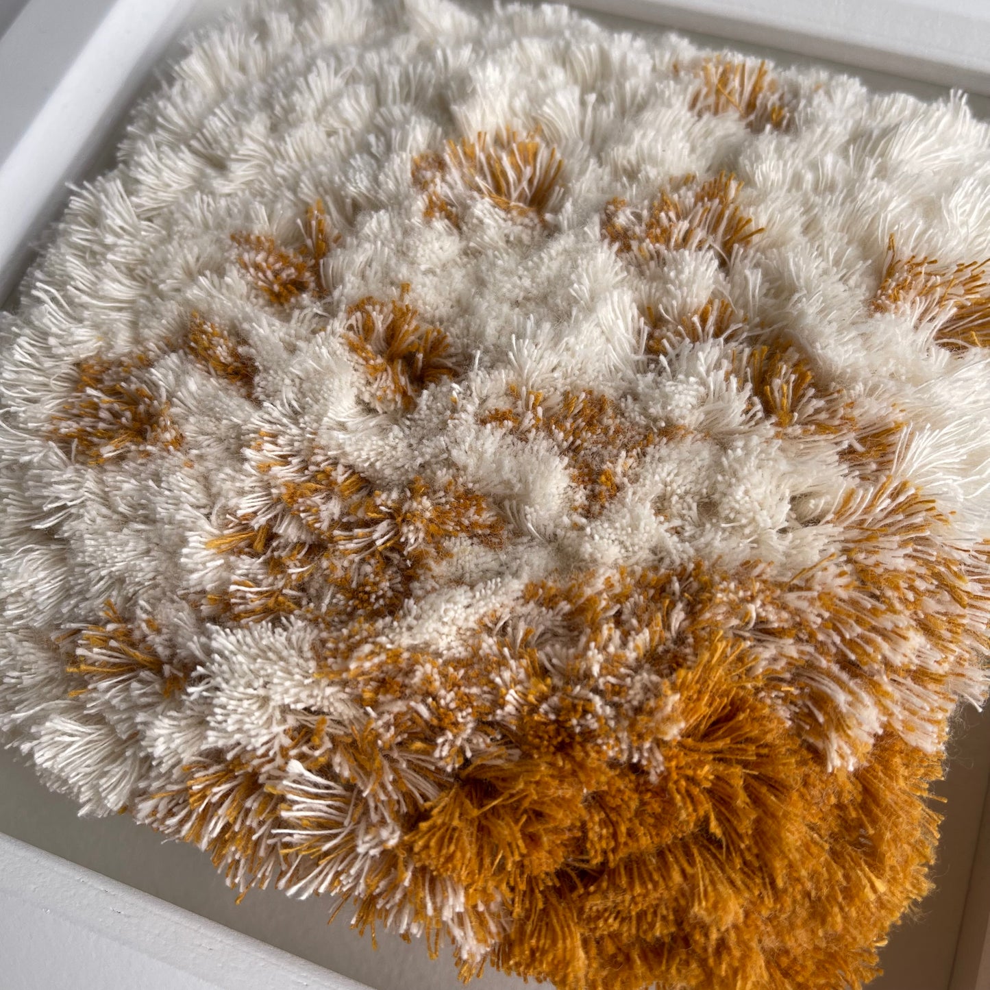 Close up detail of cream and yellow ochre fluffy textured woven textile art
