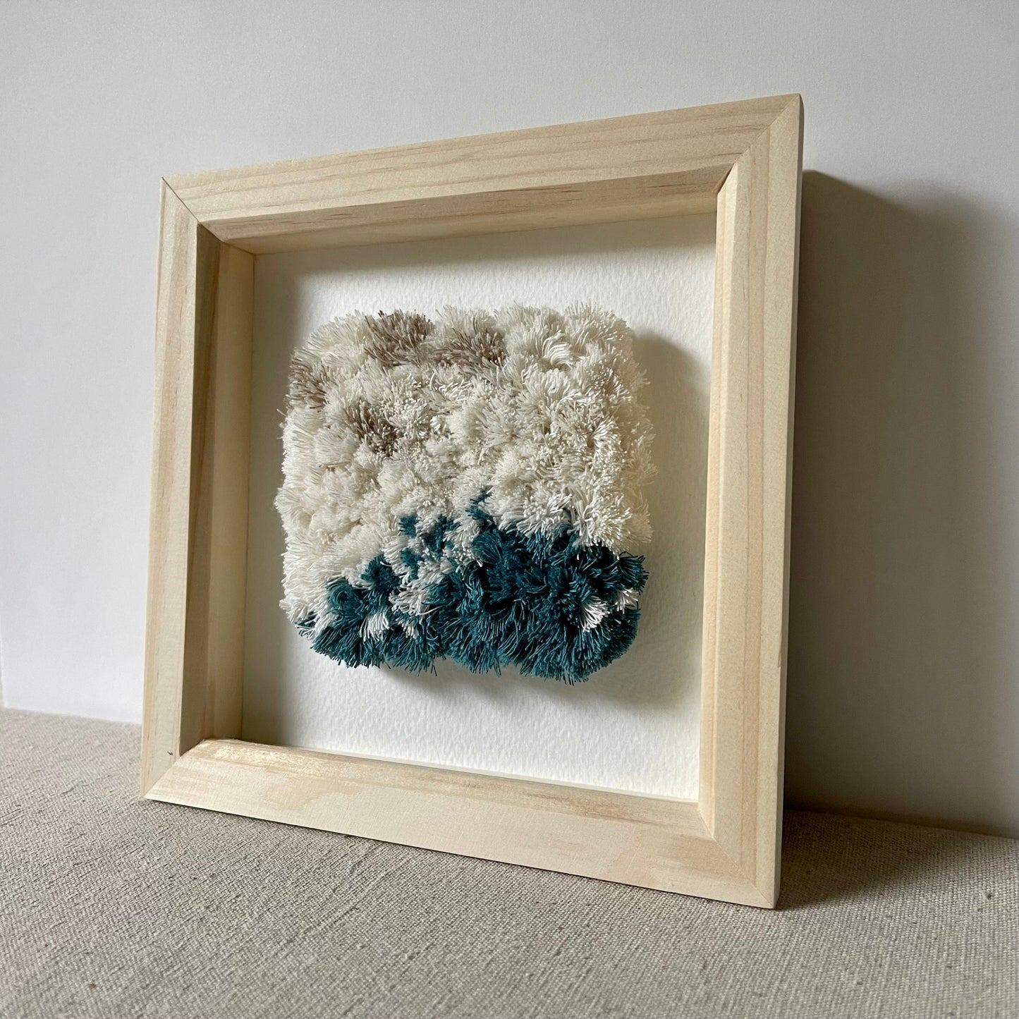 Cream and ocean teal woven fluffy textured  art in a square wood box frame