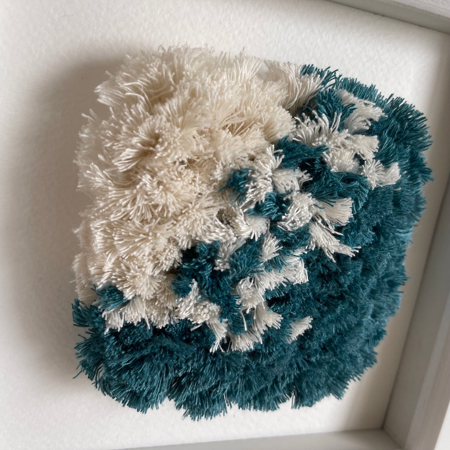 Close up detail of  fluffy textured woven wall art in ocean teal and cream