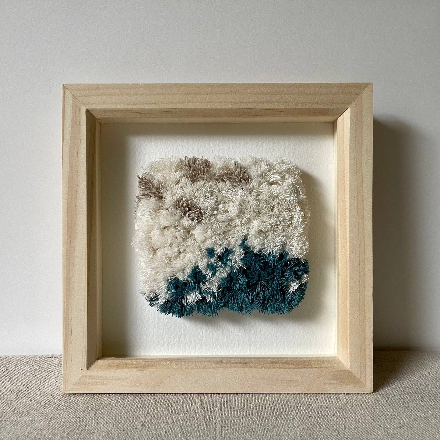 Cream and ocean teal woven fluffy textured  wall art in a square wood deep box frame