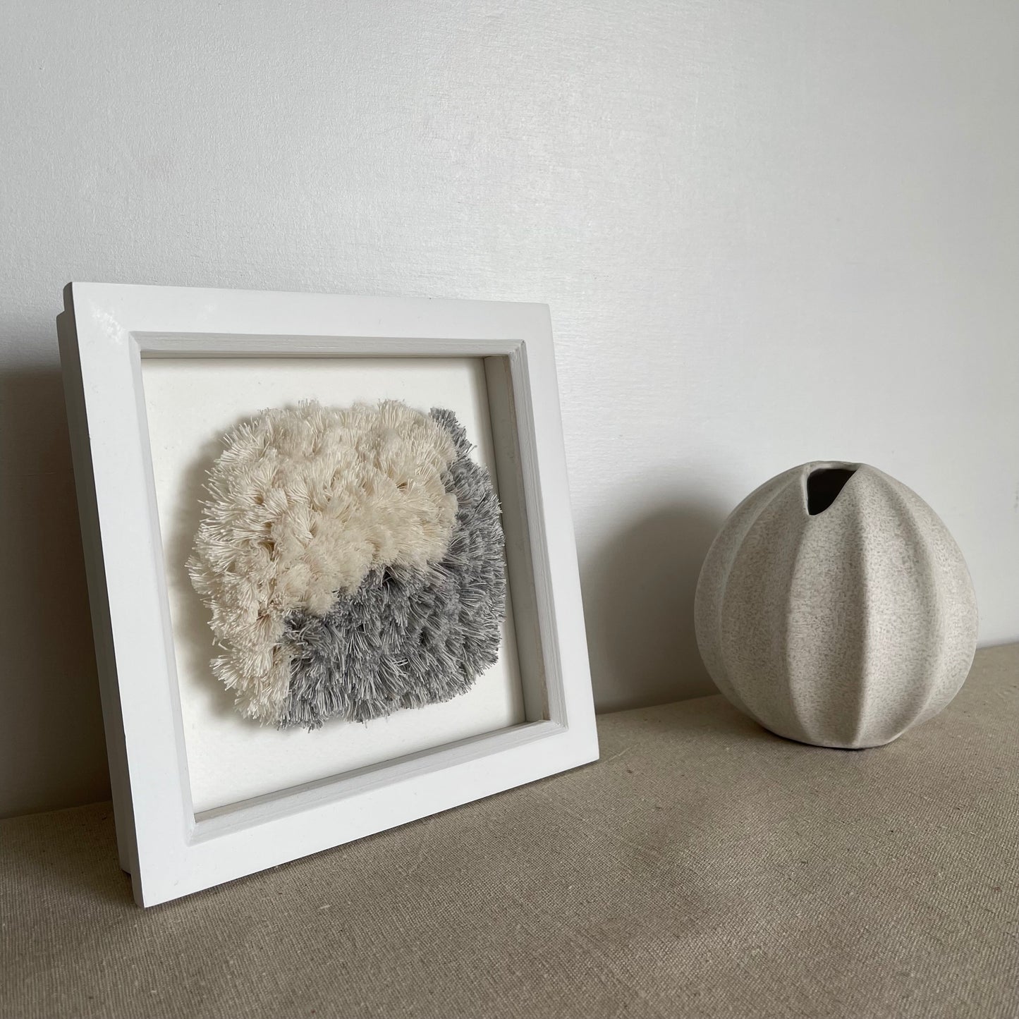 Blue and cream fluffy textured woven textile art in square white painted wood deep box frame