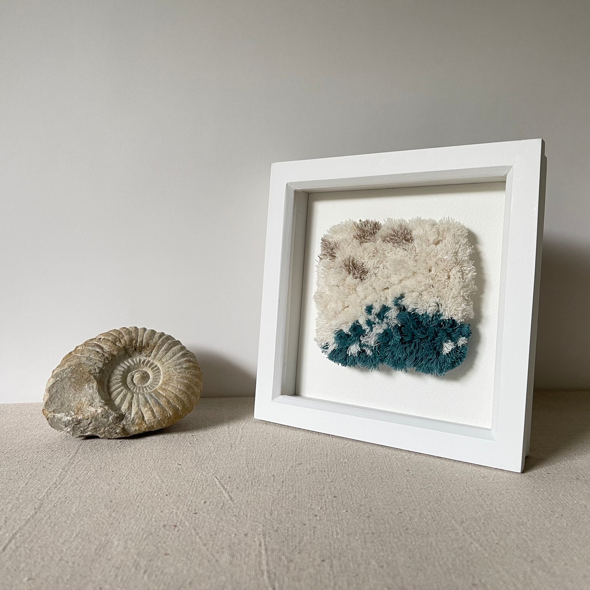 Cream and ocean teal woven fluffy textured  wall art in a square white painted wood deep box frame