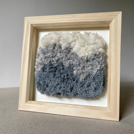 Cream and blue fluffy textured woven textile art in square natural wood deep box frame