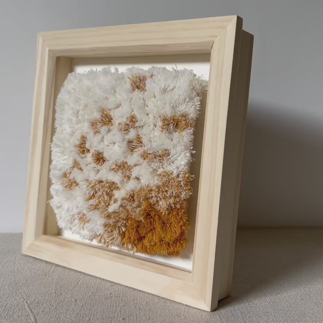 Video of cream and yellow ochre fluffy textured woven textile art in natural wood deep box frame