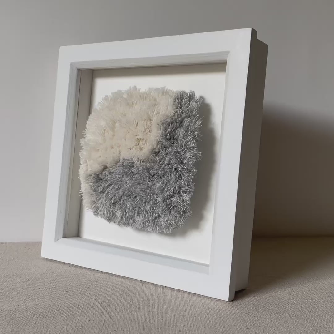 Video of blue and cream fluffy textured woven textile art in square white painted wood deep box frame