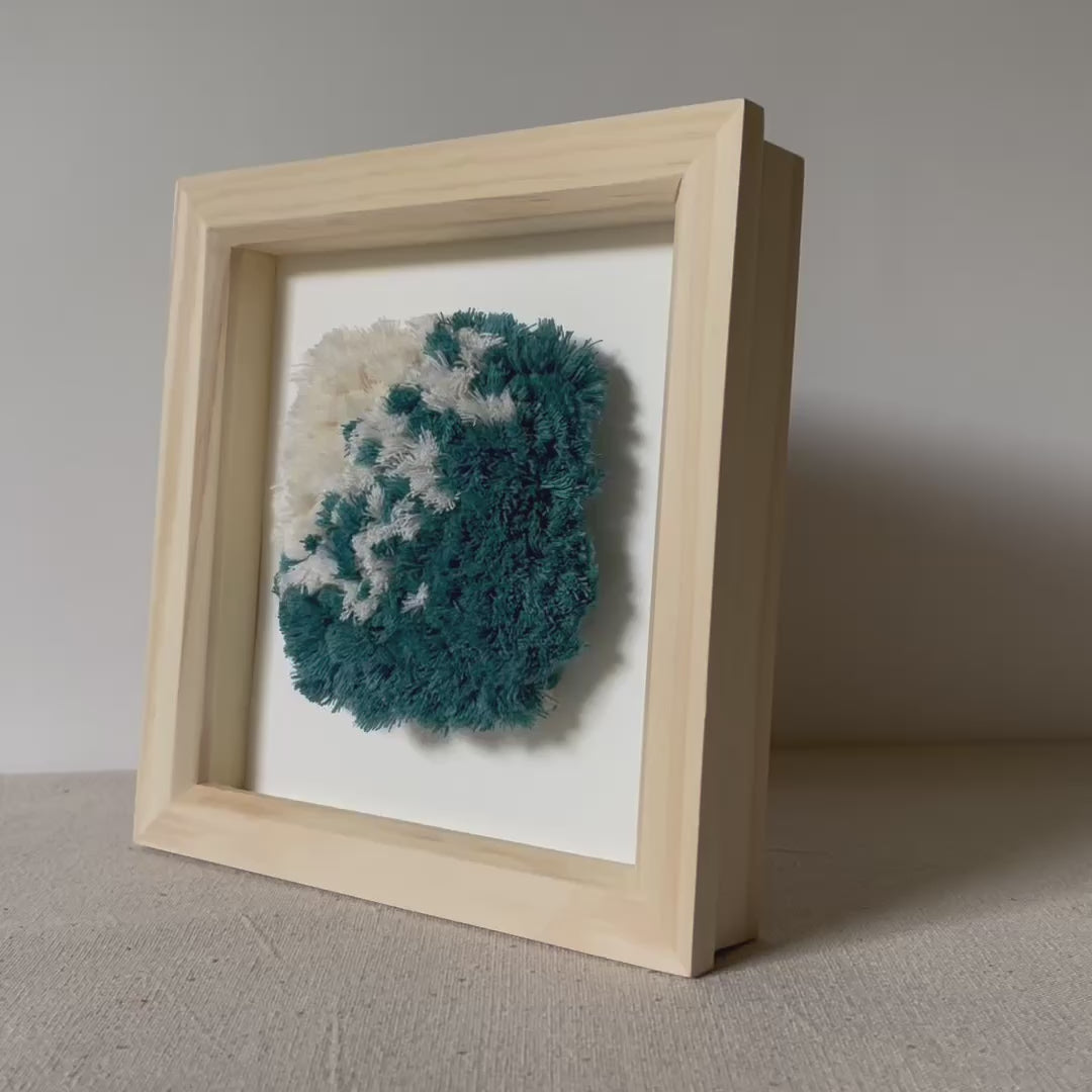 Video of ocean teal and cream fluffy textured woven wall art in a square wood deep box frame