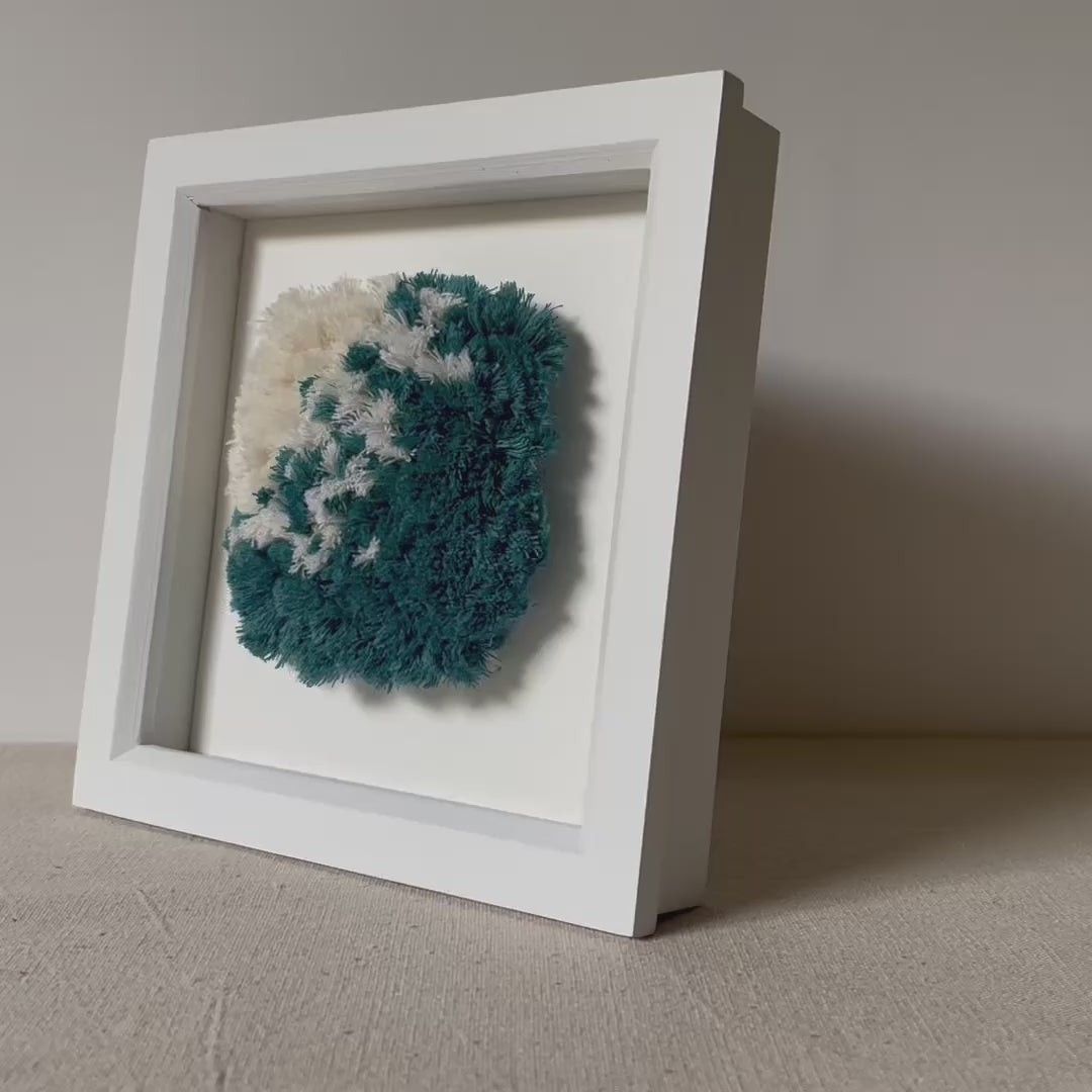 Video of ocean teal and cream fluffy textured woven wall art in a square white painted wood deep box frame