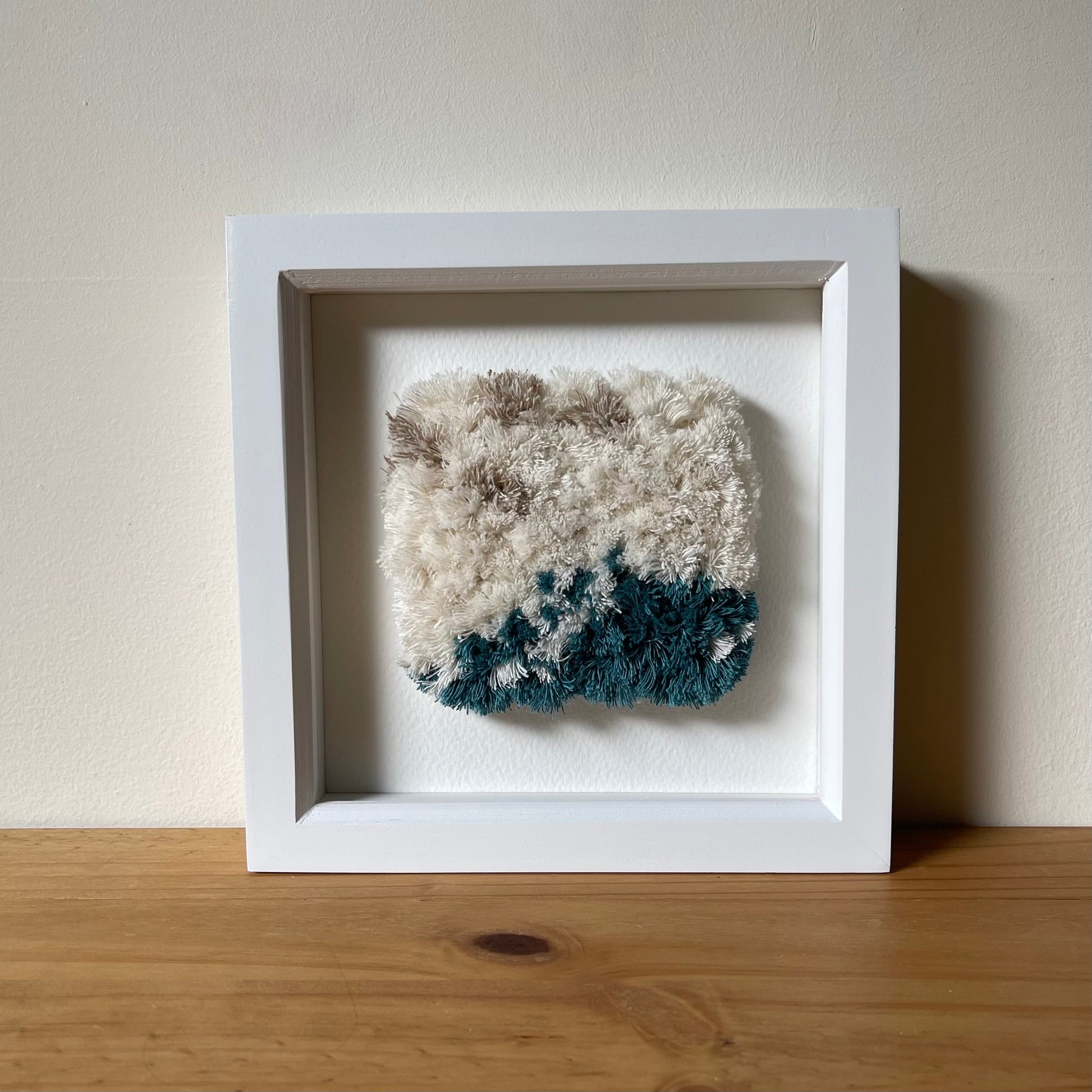 Square framed cream and ocean teal woven fluffy textured wall art