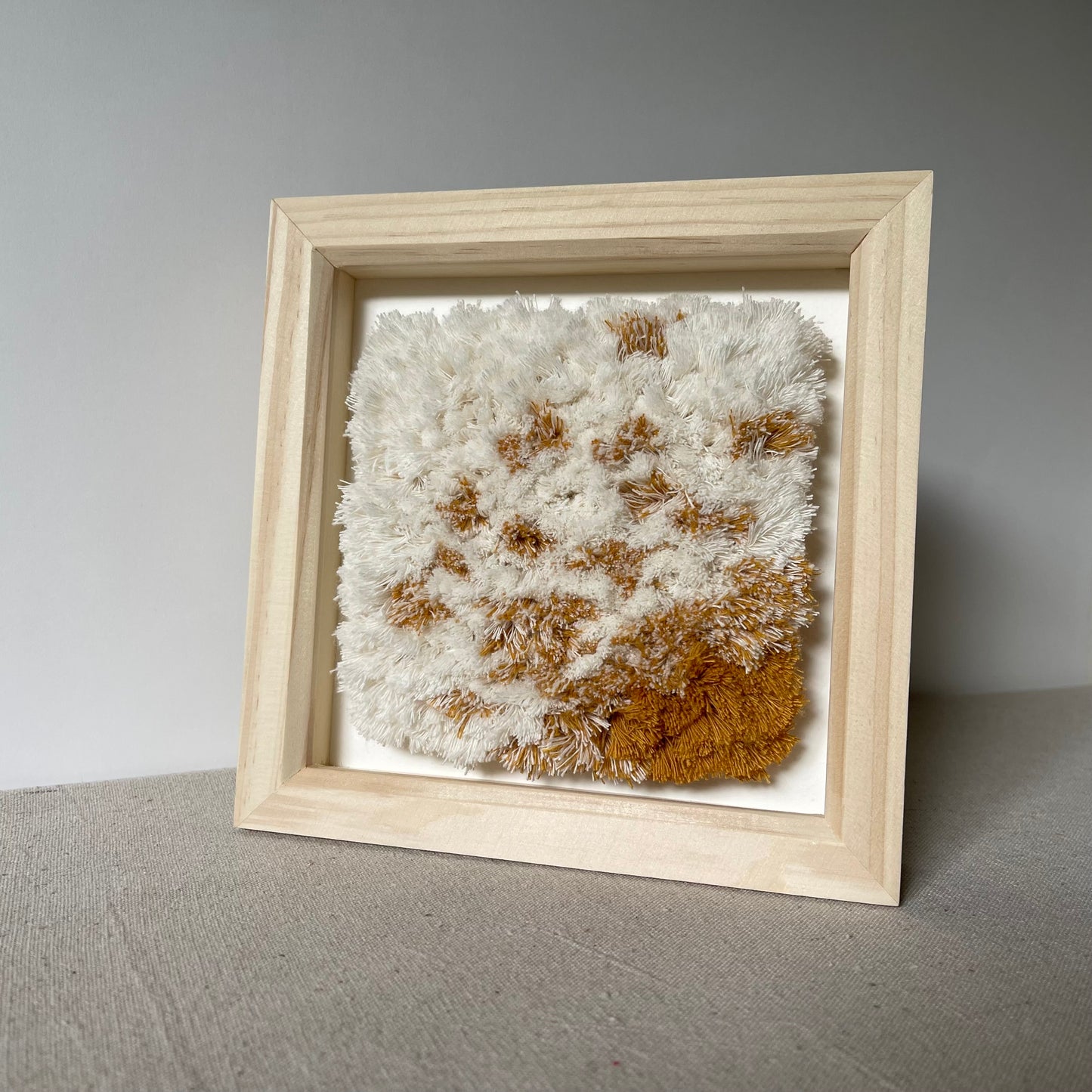 Cream and yellow ochre textured woven textile art in natural wood deep box frame