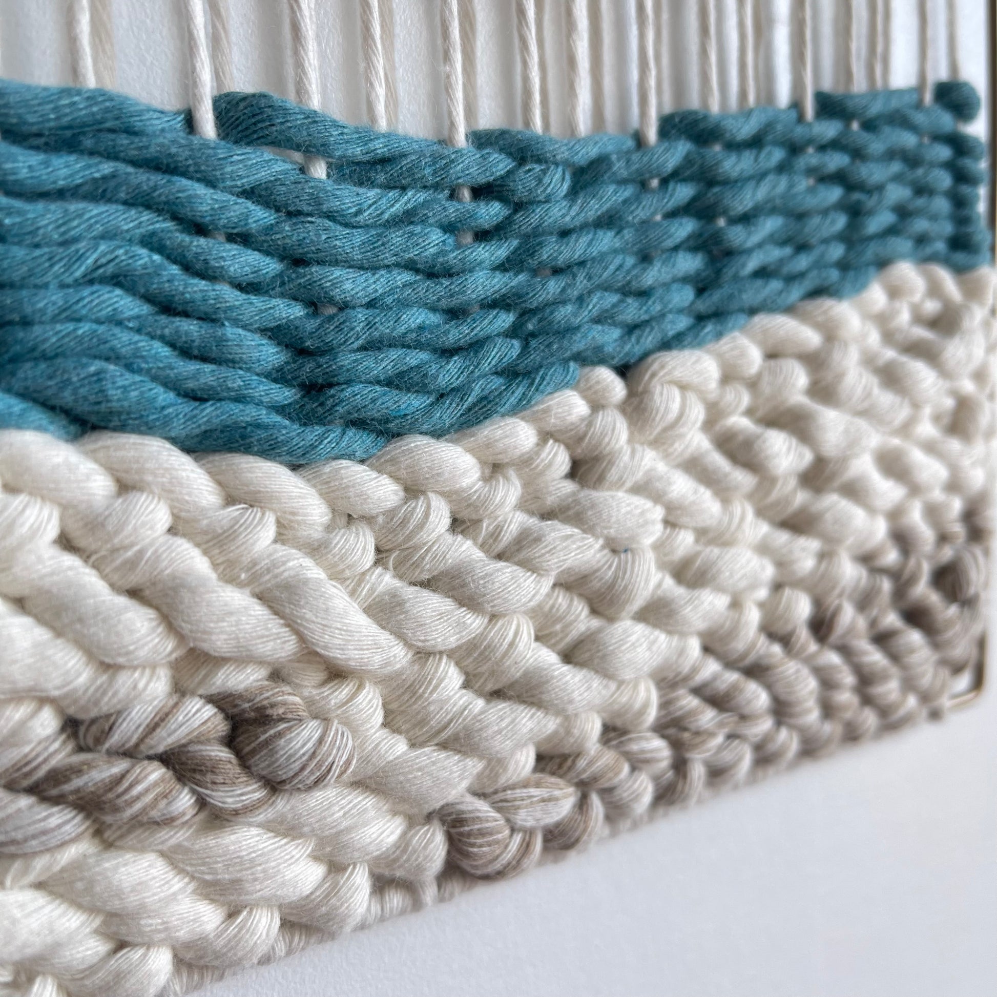 Close up of weaving technique and texture emulating waves meeting the sandy beach.
